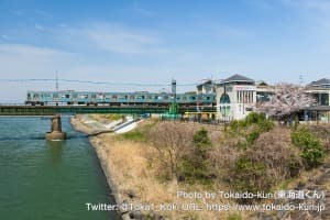 桜咲く宇治川を通過する205系